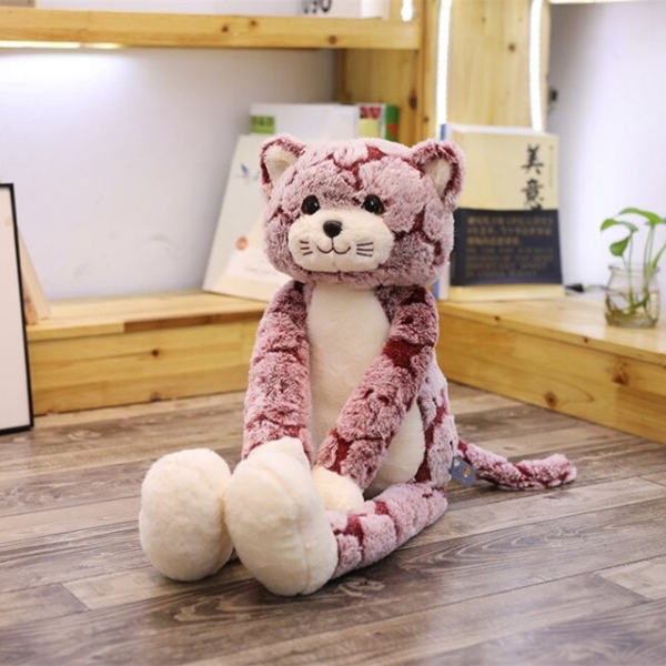 Gatto di peluche rosa a zampe lunghe seduto nella stanza di un bambino