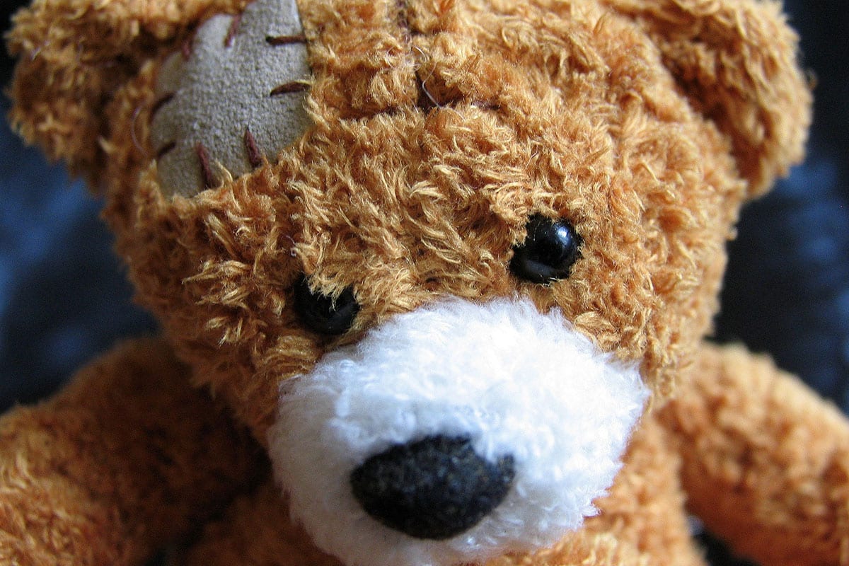 Un orsacchiotto di peluche con un panno cucito sulla testa