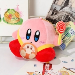 Kirby peluche rosa, seduto con un bastoncino di zucchero