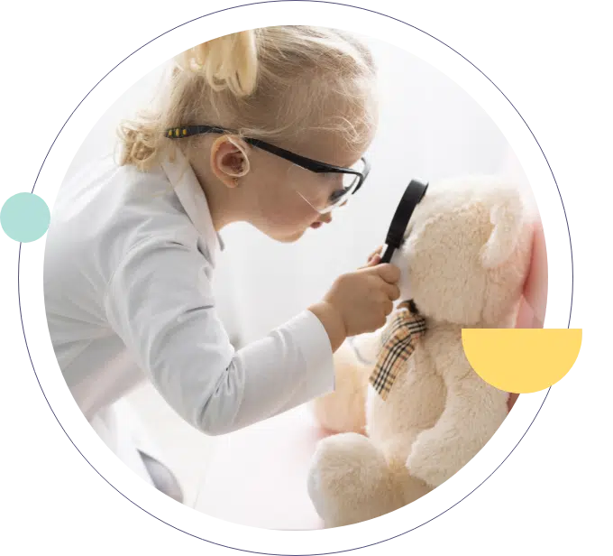 Una bambina che esamina il suo orsacchiotto con una lente di ingrandimento